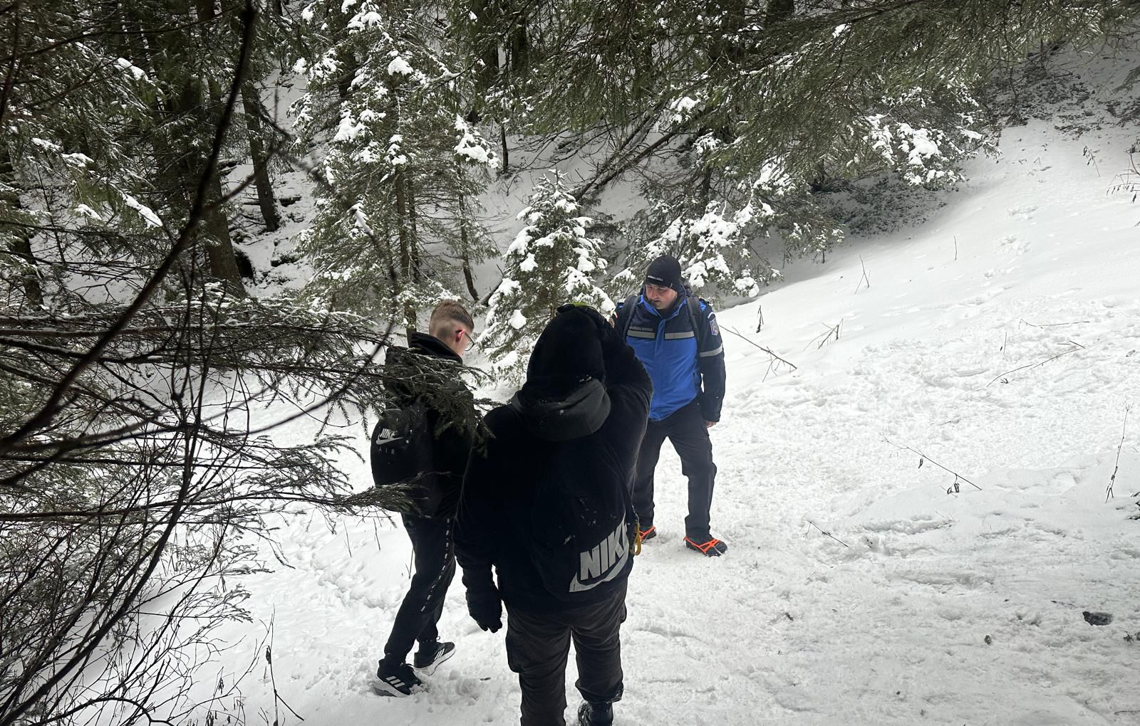 Tineri încălțați cu adidași pe munte, în plină iarnă, întorși din drum de jandarmii montani